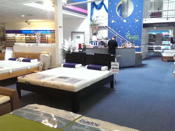 Matratzen- und Bettenausstellung im Möbelhaus mit Beratungstresen und Lattenrosten